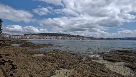 Detrás-Del-Acantilado,-Un-Pequeño-Y-Lujoso-Pueblo-Vacacional-De-Costosos-Apartamentos-En-La-Costa-Atlántica,-Un-Día-Con-Mar-En-Calma-Y-Espectaculares-Nubes-Bajas,-Toma-Panorámica-Bloqueada