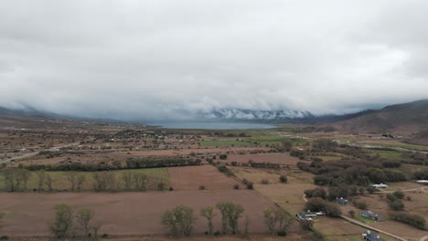 Aerial-above-Tafi-del-Valle-valley-with-distant-mountains-and-reservoir