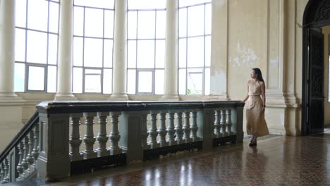 Woman-in-traditional-dress-walking-inside-Ho-Chi-Minh-City-Museum,-Vietnam