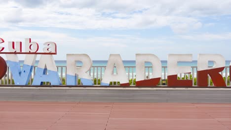 Varadero-sign-with-heart-on-beach-in-Cuba,-panning-shot