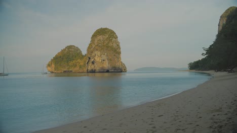 Ruhiges-Meer-An-Einem-Abgelegenen-Strand-An-Der-Eisenbahnlinie-Mit-Einer-Klippe-Im-Hintergrund