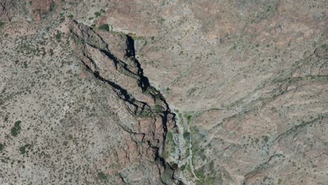 Stunning-Aerial-View-of-Rocky-Desert-Terrain-with-Rugged-Cliffs-and-Sparse-Vegetation