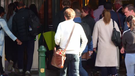 Commuters-at-Flinders-Street-Station-in-Melbourne-city-rush-to-board-trains,-hurrying-towards-the-platforms,-passing-through-gates,-and-paying-fares-by-tapping-Myki-card-on-the-payment-machines