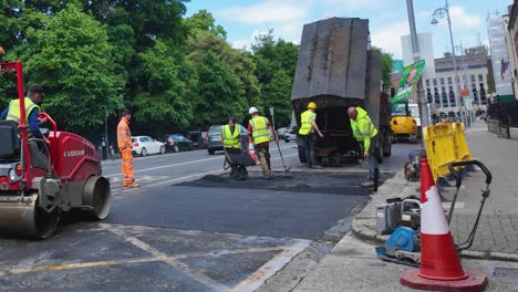 Eine-4K-Statikaufnahme-Von-Arbeitern,-Die-Eine-Straße-In-Der-Nähe-Von-St.-Stephen&#39;s-Green-Dublin-Mit-Asphalt-Reparieren