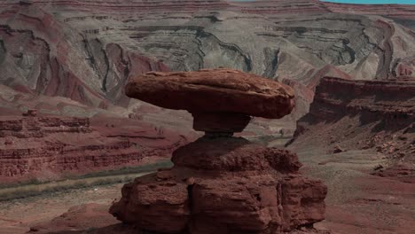 Epic-aerial-wrap-around-of-Mexican-Hat-rock-in-southern-Utah-with-dramatic-background