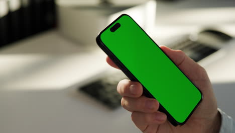 Right-hand-looking-at-smartphone,-green-screen-template