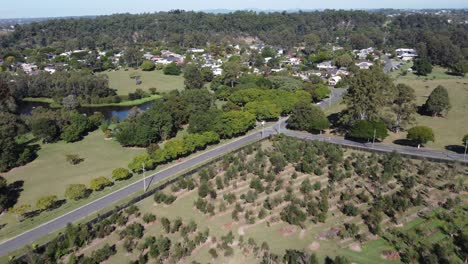 Drohne-Fliegt-über-Obstbäume-In-Richtung-Eines-Kleinen-Sees-Und-Eines-Wohngebiets-In-Australien