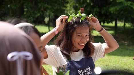 An-Indonesian-girl-tries-on-plant-crowns-at-the-Sunset-di-Kebun-outdoor-concert-event