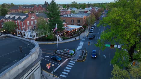 Busy-town-square-with-American-flag-at-dusk