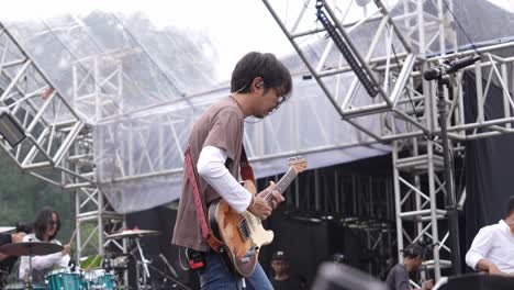 Fiersa-Besari-Tocando-La-Guitarra-En-El-Escenario-Al-Atardecer-En-El-Concierto-Al-Aire-Libre-Del-Jardín