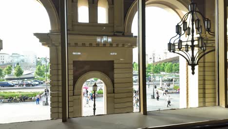 Una-Vista-Desde-Una-Ventana-Dentro-De-Un-Gran-Edificio,-Con-Ventanas-Arqueadas-Y-Candelabros-Ornamentados