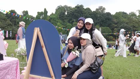 Indonesian-women-in-hijabs-taking-a-group-selfie-at-an-outdoor-concert-event