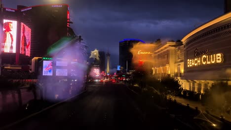 Driving-on-Las-Vegas-Strip-on-Rainy-Night,-Raindrops-on-Windshield-With-Abstract-Reflections