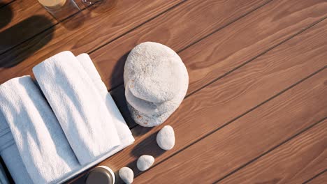 Spa-wellness-setting-with-flowers,-towels,-healing-rocks,-and-spa-treatment-creams-on-wooden-surface,-on-day-time,-3D-animation,-SPA-salon-treatment,-relaxation,-camera-top-view