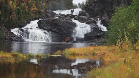 Serenity-reigns-as-a-waterfall-flows-gracefully-through-the-lush-greenery-of-a-Norwegian-forest,-creating-a-tranquil-oasis