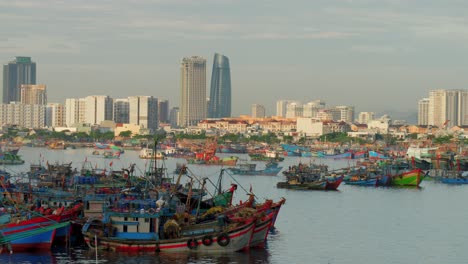 Da-Nang,-Vietnam---Traditionelles-Fischerboot,-Das-In-Der-Bucht-Vor-Anker-Liegt,-Mit-Skyline-Stadtbild-In-Der-Ferne