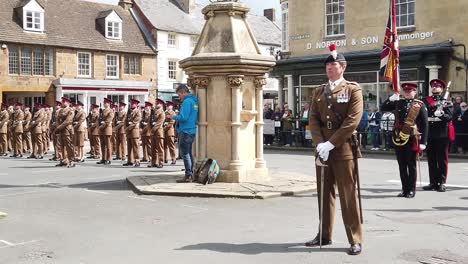 British-officer-of-the-Royal-Anglian-regiment-standing-at-ease-with-his-sword-while-on-parade-in-a-local-town-to-his-barracks