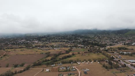 Majestic-aerial-view-above-the-city-Tafì-del-Valle-with-cloudy-mountain-landscape-in-Tucumán,-Argentina