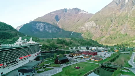 Kreuzfahrtschiff-Angedockt-In-Einer-Malerischen-Norwegischen-Fjordstadt,-Umgeben-Von-Majestätischen-Bergen-Und-Viel-Grün