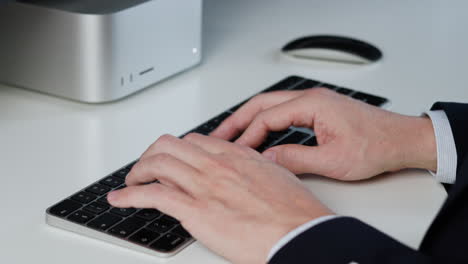 Male-hands-typing-on-wireless-keyboard-with-black-keys