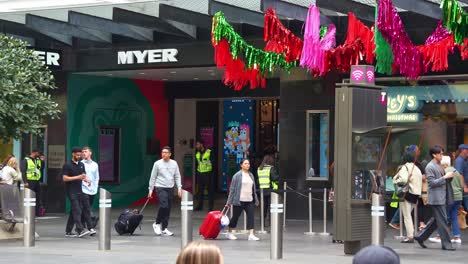 Bluey's-Christmas-display-on-Myer's-windows-in-bustling-Melbourne-City,-Bourke-Street-Mall,-with-pedestrians-and-shoppers-stroll-by-captured-in-slow-motion-shot-that-highlights-the-festive-atmosphere