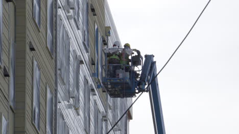 Painters-wipe-their-hands-and-move-the-next-spot-on-a-JLG-lift-high-in-the-air