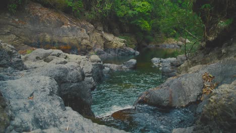 Río-Panorámico-Que-Fluye-A-Través-De-Un-Terreno-Rocoso-Rodeado-De-Exuberante-Vegetación-En-El-Parque-Nacional-De-Khao-Sok,-Tailandia