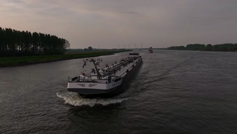 River-sunsetting-scenery,-commercial-shipping-route-Netherlands,-aerial