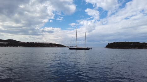 Sailing-boat-with-sails-down-floating-on-the-calm-waters-of-the-Elafiti-Islands,-Croatia,-embodying-the-concept-of-serene-maritime-relaxation-and-coastal-exploration