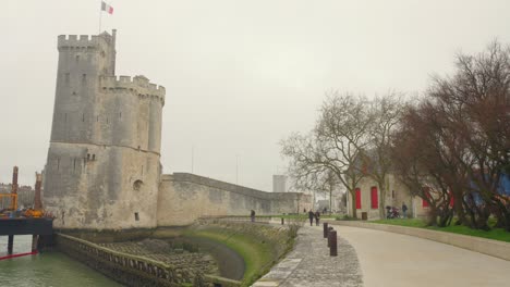 Wide-angle-shot-of-Towers-of-La-Rochelle-:-Saint-Nicolas-tower-in-La-Rochelle,-France-on-a-mist-day