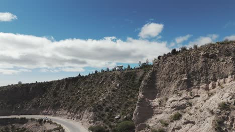 Aerial-view-of-rocky-cliffside-with-the-astromical-observatory-buildings-on-top-of-the-mountain-in-Amaicha-del-Valle,-Argentina