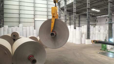 Man-arranging-large-paper-rolls-inside