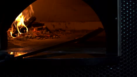 Cooking-a-fresh-cheesy-pizza-in-an-old-school-wood-fire-stone-oven