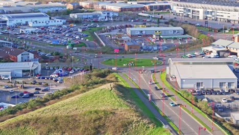 Suburbs-of-Debry-are-inhabited-by-lots-of-cars,-parked-and-moving-along-the-road-to-the-roundabout