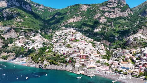 Close-Up-View-of-Positano-Colorful-Coastal-Homes,-Surrounded-by-Lush-Vegetation,-Turquoise-Water-and-Fast-Moving-Clouds,-Amalfi-Coast,-Italy,-Europe