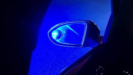 Police-Emergency-Lights-in-Rearview-Mirror-of-Car-at-Night,-Close-Up