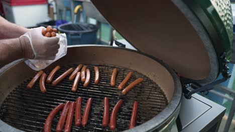 Kein-Gesichtsvideo-Von-Einem-Koch,-Der-Würstchen-Zum-Braten-In-Den-Smoker-Legt