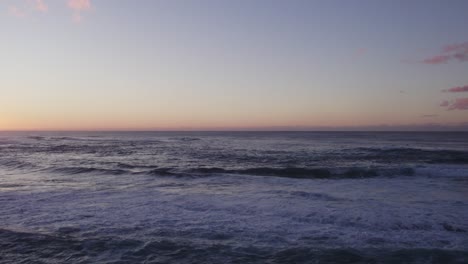 A-serene-sunset-over-the-North-Shore-of-Oahu,-capturing-the-calm-waves-and-pastel-hues-of-the-sky-as-the-sun-sets-over-the-horizon