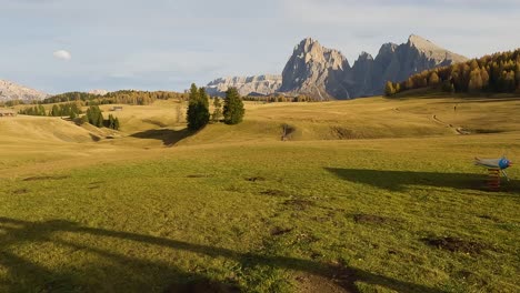 POV-Hin-Und-Her-Schwingen-über-Grasfelder-Mit-Blick-Auf-Die-Dolomiten-In-Der-Ferne,-Italien