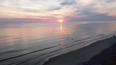 Drone-footage-of-a-serene-sunset-over-the-Baltic-Sea-at-The-Dutchman's-Cap,-Lithuania