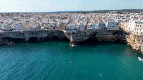 Luftaufnahme-Von-Polignano-A-Mare-Mit-Vögeln-Und-Türkisfarbenem-Wasser,-Italien