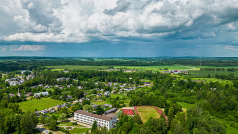 Billowing-clouds-over-a-countryside-village---aerial-hyper-lapse