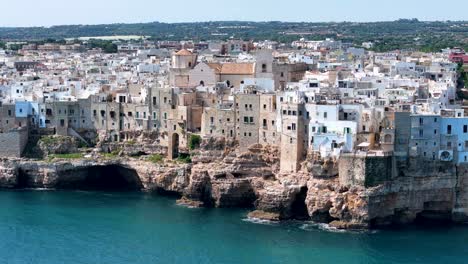 Vista-Aérea-Circular-De-Polignano-A-Mare-Ciudad-Al-Borde-De-Un-Acantilado-Escarpado-En-Puglia,-Italia,-Mar-Adriático