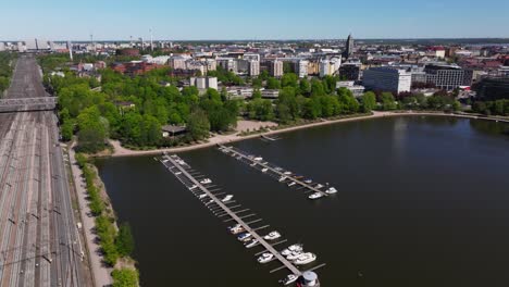 Aerial-dolly-above-empty-train-tracks-and-harbor-docks-to-Helsinki-Finland-cityscape-skyline