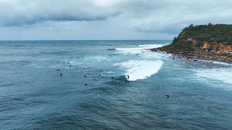 Surfers-Surfing-Ocean-Waves-Cloudy-Summer-Day-Rocky-Coastline-Sydney-Slowmo-Video