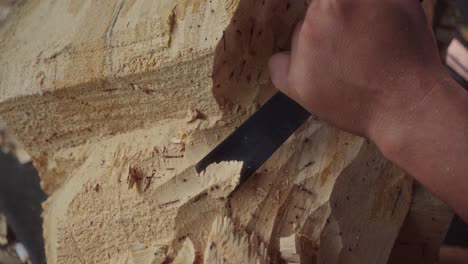 Skillful-hands-of-a-Balinese-wood-carver-using-a-curved-chisel-and-mallet-on-woodworking-to-make-Barong-Bangkung,-a-traditional-dance-wooden-mask