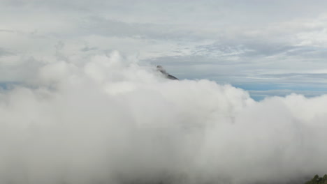 Dicke,-Flauschige-Weiße-Wolken-Schweben-Langsam-über-Den-Himmel-Und-Geben-Den-Blick-Auf-Dunkelgrauen-Rauch-Vom-Vulkan-Frei