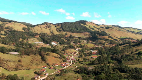 A-drone-footage-captures-a-breathtaking-view-of-a-small-village-located-in-a-valley-surrounded-by-rolling-hills