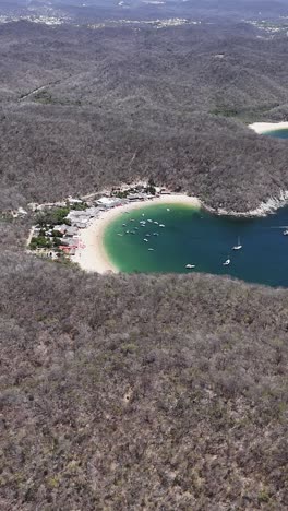 Aerial-view-of-a-beach-in-Huatulco,-Oaxaca,-vertical-mode