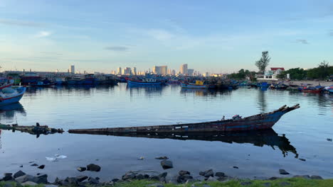 Elendes-Fischerboot-Aus-Traditionellem-Holz-In-Da-Nang-Mit-Stadtbild-In-Der-Ferne